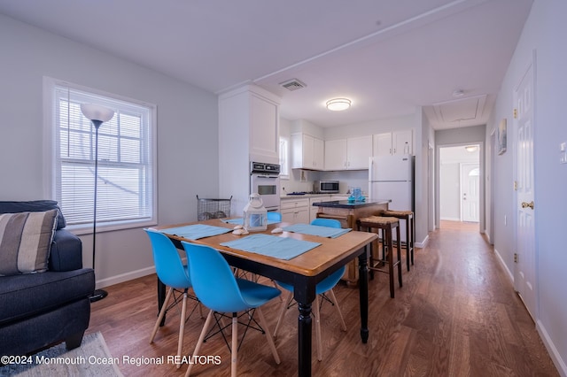 dining room featuring baseboards, visible vents, dark wood finished floors, and attic access
