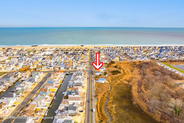 bird's eye view featuring a water view, a beach view, and a residential view