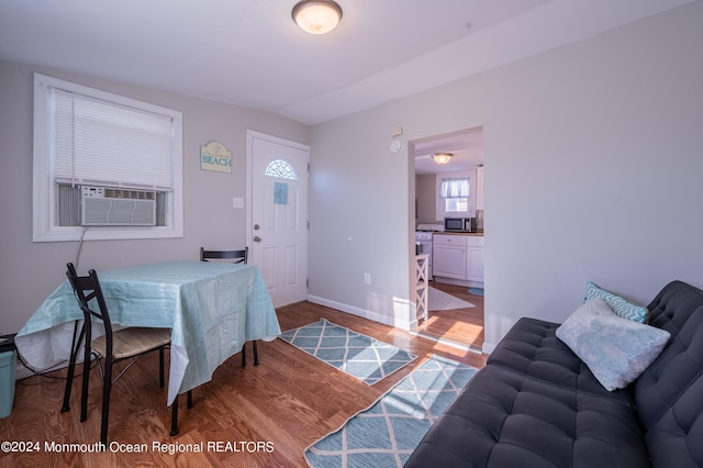 dining space featuring baseboards, cooling unit, and wood finished floors