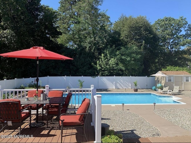 view of swimming pool with a fenced backyard and an outbuilding