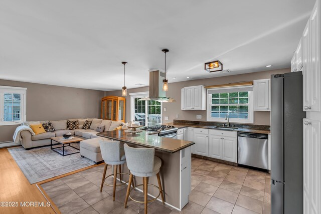 kitchen with stainless steel appliances, a sink, plenty of natural light, white cabinets, and recessed lighting