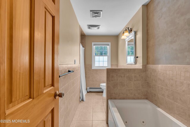 bathroom featuring tile walls, toilet, tile patterned floors, baseboard heating, and a whirlpool tub