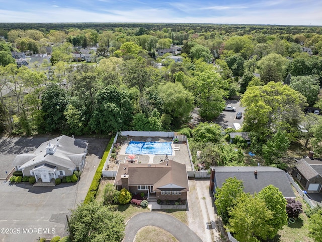 aerial view of a heavily wooded area and a pool