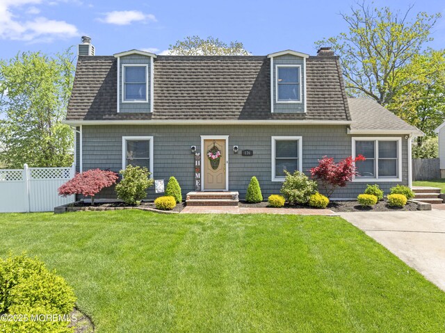 view of front of property with fence, a chimney, and a front lawn