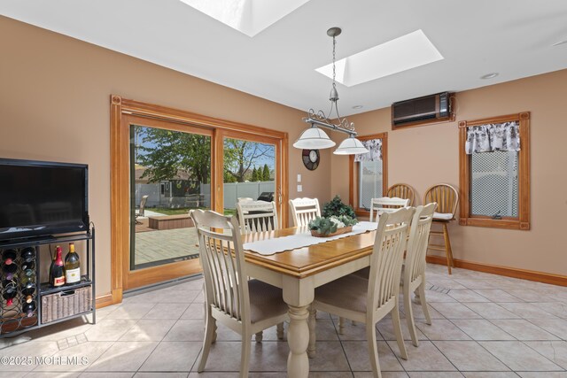 dining space with a skylight, light tile patterned floors, baseboards, and a wall unit AC