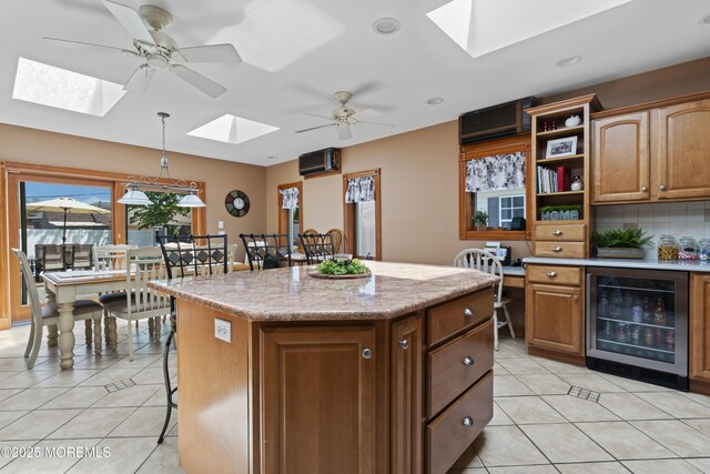 kitchen with light tile patterned flooring, open shelves, a breakfast bar area, wine cooler, and a skylight