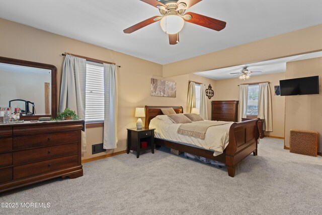 carpeted bedroom featuring baseboards, a ceiling fan, and visible vents