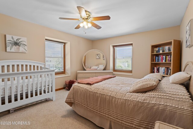 carpeted bedroom featuring baseboards and ceiling fan