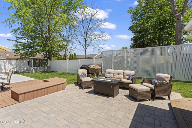 view of patio / terrace with an outdoor structure, a storage shed, an outdoor hangout area, and a fenced backyard