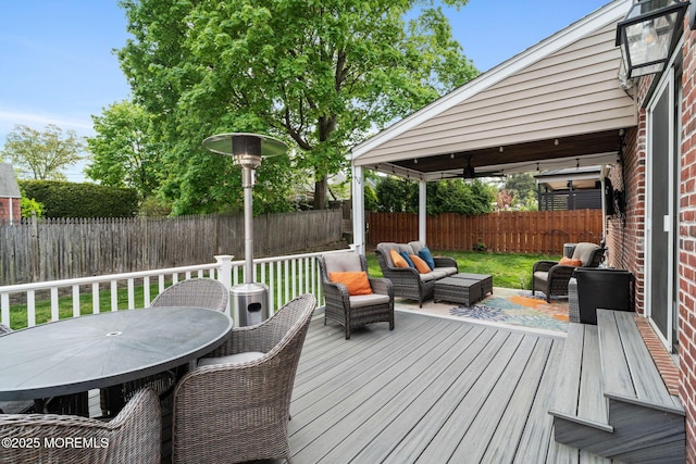 wooden deck featuring an outdoor living space, a fenced backyard, and outdoor dining space