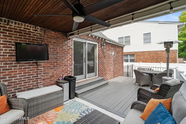 wooden terrace featuring ceiling fan, fence, and outdoor dining space