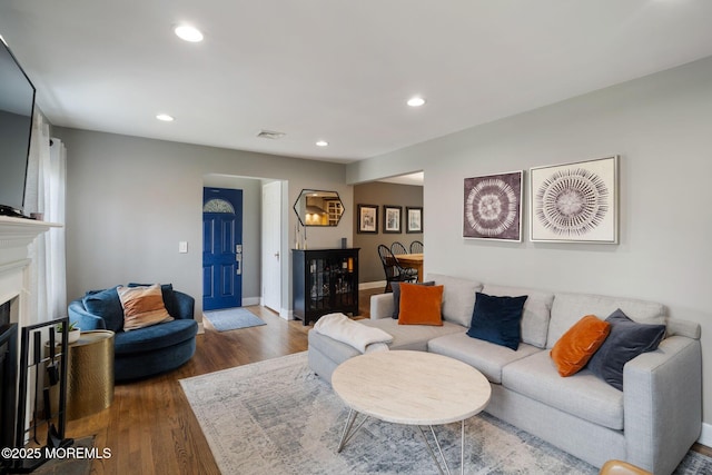 living area with visible vents, a fireplace, wood finished floors, baseboards, and recessed lighting