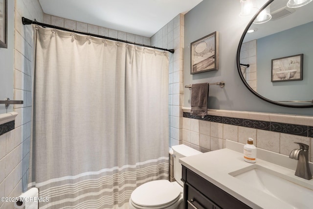 full bathroom featuring vanity, toilet, tile walls, a shower with curtain, and visible vents