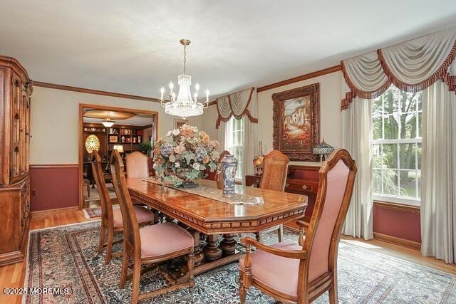 65 Devonshire Dr, Morganville, NJ 07751 - dining area with light wood-style floors, baseboards, crown molding, and a notable chandelier