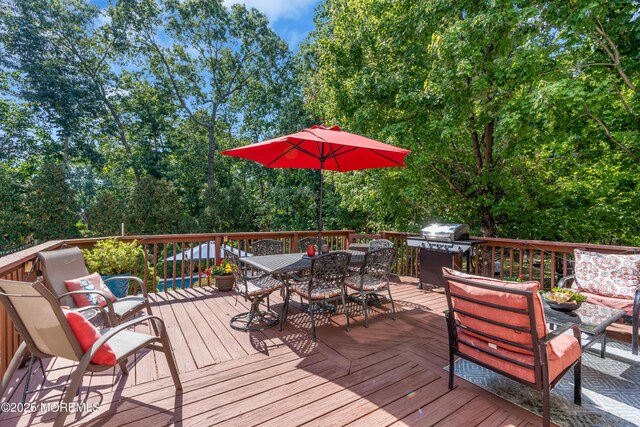 deck with outdoor dining area and grilling area