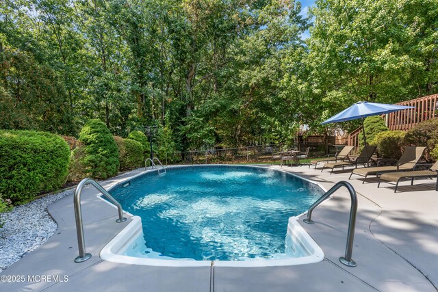 view of swimming pool featuring a patio, fence, and a fenced in pool