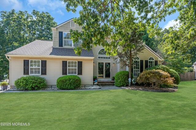 traditional home with roof with shingles and a front lawn