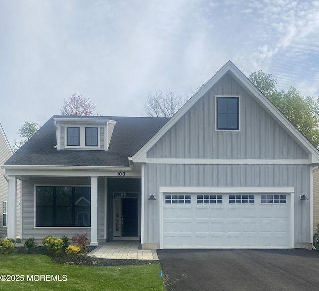 103 Wisteria Ct, Freehold, NJ 07728 - view of front facade with roof with shingles, aphalt driveway, a garage, board and batten siding, and covered porch