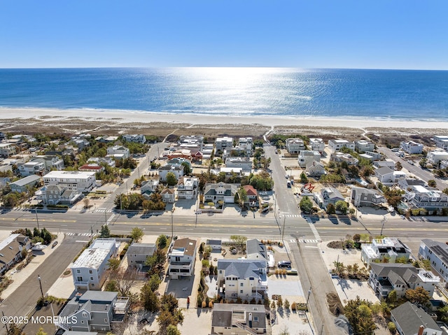 bird's eye view with a water view, a beach view, and a residential view