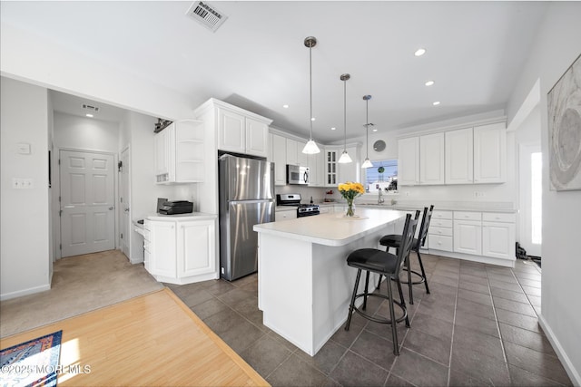 kitchen with a kitchen island, visible vents, appliances with stainless steel finishes, open shelves, and white cabinets