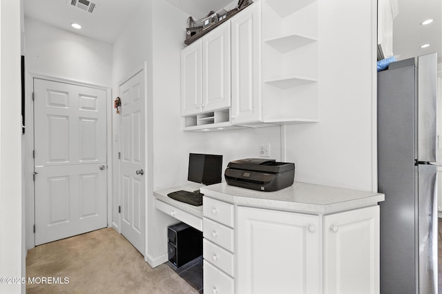 office featuring recessed lighting, visible vents, light carpet, and built in study area