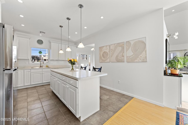 kitchen with recessed lighting, a wealth of natural light, a sink, and a center island