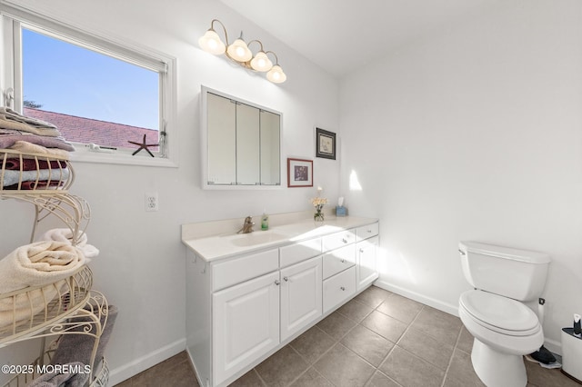 bathroom featuring toilet, baseboards, tile patterned floors, and vanity
