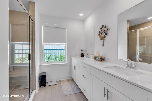 bathroom with a sink, baseboards, and a shower stall