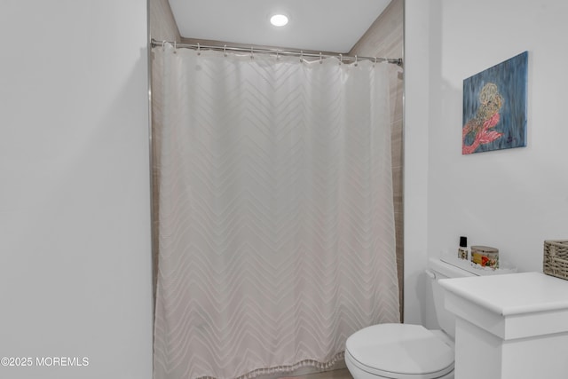 bathroom featuring curtained shower and toilet