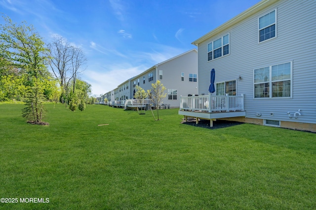 back of house featuring a lawn and a wooden deck