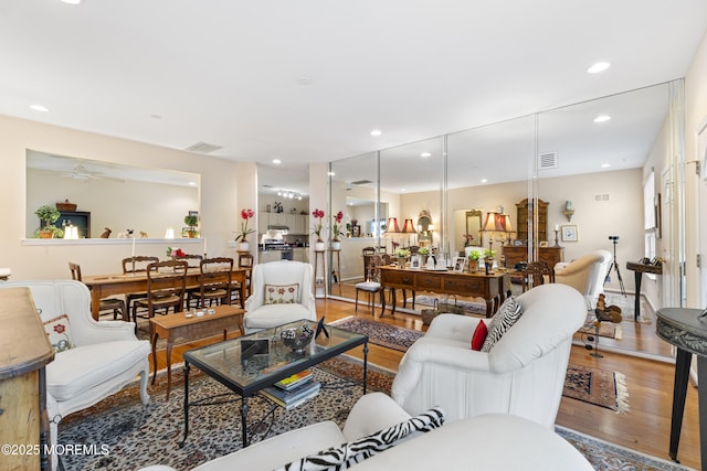 living area with visible vents, wood finished floors, ceiling fan, and recessed lighting