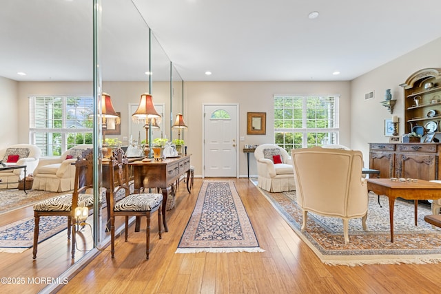 living room with recessed lighting, light wood finished floors, and visible vents