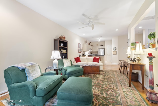living area with a ceiling fan, light wood-style floors, recessed lighting, and baseboards