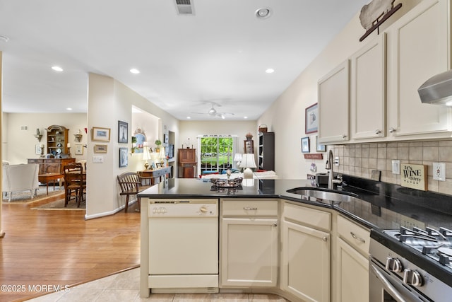 kitchen with a peninsula, a sink, visible vents, ceiling fan, and dishwasher