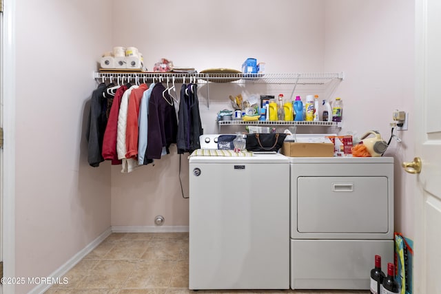 clothes washing area featuring laundry area, baseboards, light tile patterned floors, and independent washer and dryer