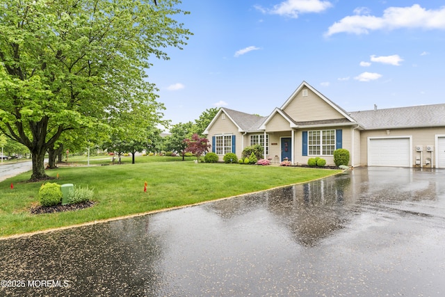 ranch-style house featuring a front lawn, aphalt driveway, and an attached garage