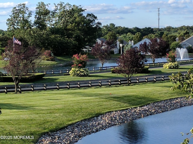 view of property's community featuring a yard and a water view