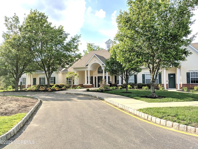 view of front of house featuring brick siding, french doors, and a front yard