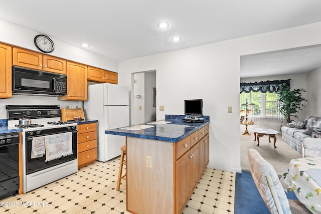 kitchen featuring a peninsula, light floors, a kitchen breakfast bar, recessed lighting, and black appliances