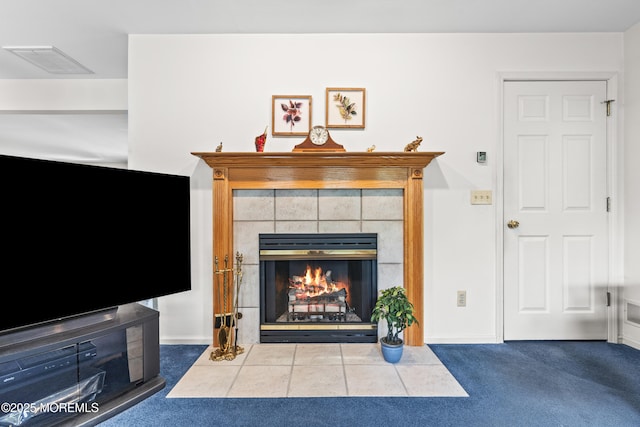 living area featuring carpet floors, baseboards, visible vents, and a fireplace