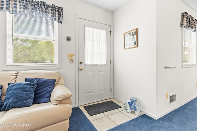 doorway featuring tile patterned floors, baseboards, and visible vents