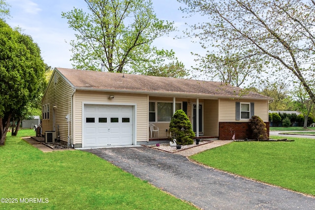ranch-style house featuring an attached garage, central AC unit, driveway, and a front yard