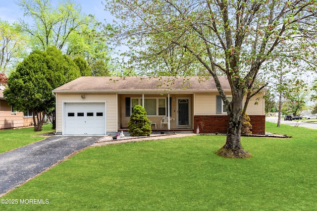 ranch-style home featuring brick siding, an attached garage, a front lawn, and aphalt driveway