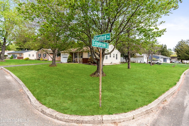 view of front of property featuring a residential view, a front lawn, and a garage