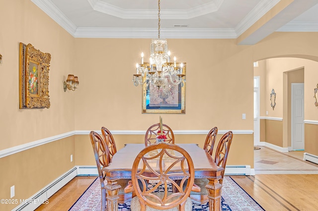 dining room featuring an inviting chandelier, arched walkways, baseboard heating, and wood finished floors