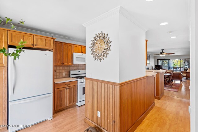kitchen with white appliances, light countertops, light wood-style flooring, a ceiling fan, and tasteful backsplash
