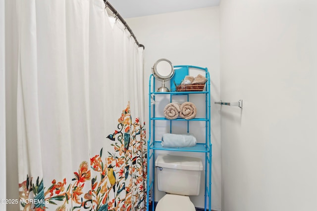 bathroom featuring a shower with shower curtain and toilet