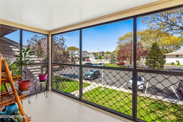unfurnished sunroom with a residential view and a healthy amount of sunlight