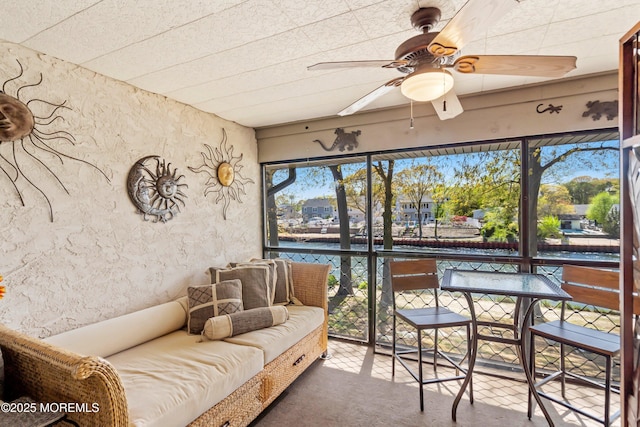 sunroom / solarium with a water view and ceiling fan