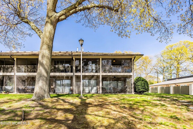 back of house with a sunroom and fence